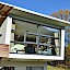 Passivhaus in Rohrbach/Gölsen – Passivhaus mit Eternit- und Holzfassade sowie großer Glasfront im vorragenden Wohnbereich